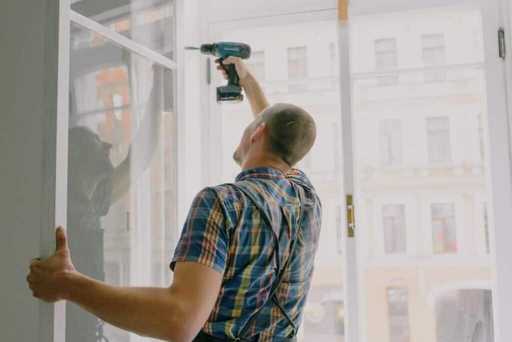 Worker installing window frame