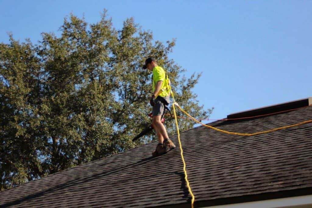 A man on roof working with a rope